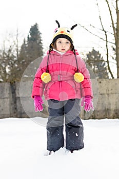 Portait of a little girl in winter clothes having fun in the sno