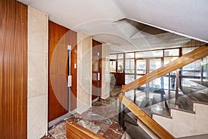 Portal with an apartment building with red marble floors and elevator doors covered with sapele wood