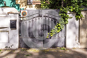 Portal of an urban single-family home with a metal fence with wrought iron work