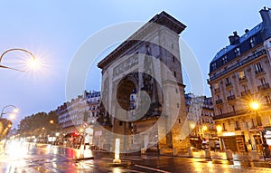 The Porte Saint-Denis triumphal arch at rainy night , Paris, France. photo