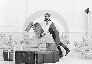 Porter, butler accidentally stumbled, dropping pile of vintage suitcases. Baggage insurance concept. Man with beard and