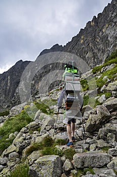 Porter carrying boxes with groceries to a mountain lodge in the High Tatras, Slovakia.