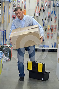 Porter carrying boxes in warehouse