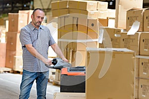 Porter carrying boxes in warehouse