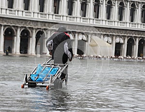 Porter with cart in Venice during flood