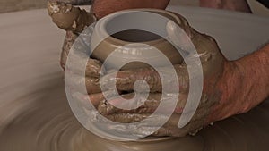 A porter cutting a clay bowl on a rotating wheel