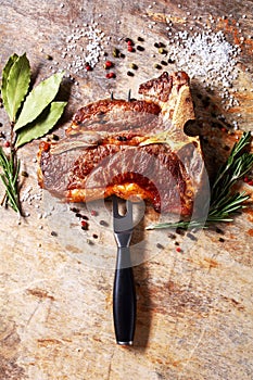 Porterhouse steak is speared with carving fork