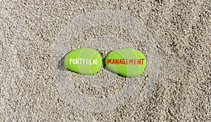 Portfolio management symbol. Concept words Portfolio management on beautiful green stone. Beautiful sea sand beach background.