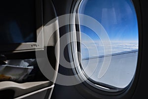 Porthole sky view. Commercial airplane window view from passenger seat