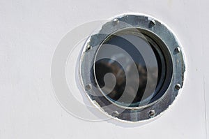 Porthole in the white hull of passenger ship