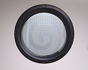 Porthole window with black frame and translucent glass reinforce