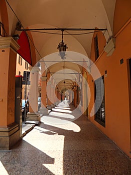 A portico in Bologna, Italy. Columns creating sharp shadows on the stone pavement