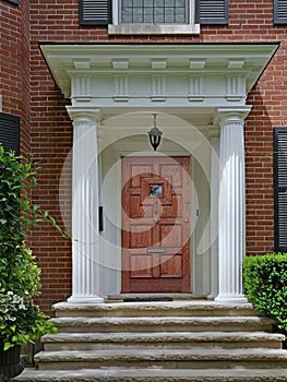 Portico entrance of brick house with large white columns