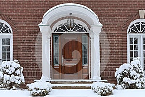 Portico entrance with elegant wood grain front door,