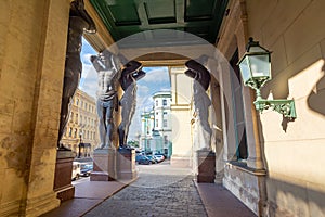 Portico of New Hermitage building with Atlantes and St. Isaac`s Cathedral at background, Saint Petersburg, Russia