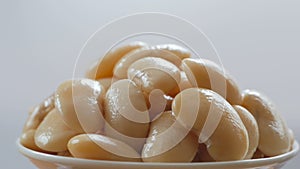 A portion of boiled white large beans rotates in the frame