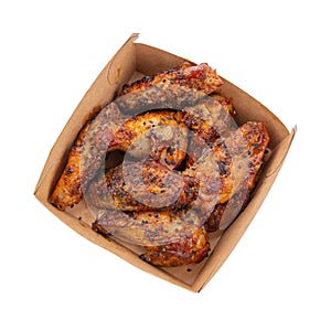 Portion of chicken wings in sauce with sesame seeds in a cardboard box isolated on white background