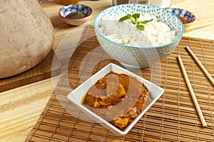 Portion of chinese chicken curry and a bowl of rice