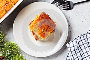 Portion of Christmas cheddar cornbread on white plate. Festive recipe food concept
