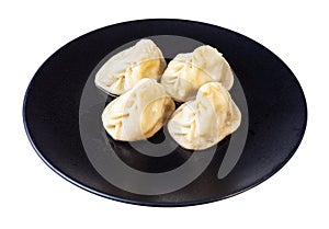 Portion of cooked Manti on black plate isolated