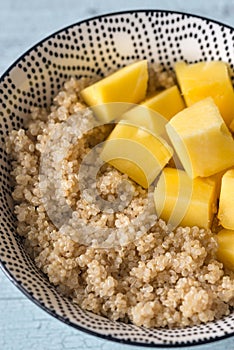 Portion of cooked quinoa with mango slices