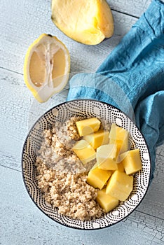 Portion of cooked quinoa with mango slices