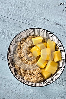 Portion of cooked quinoa with mango slices