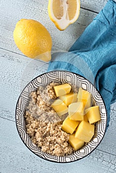 Portion of cooked quinoa with mango slices