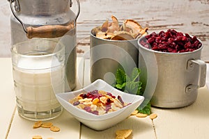 Portion of cornflakes and two aluminum cups with dried fruit