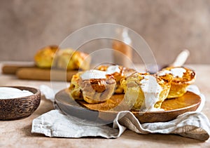 Portion Dutch baby pancakes with apples served with cream, honey and cinnamon on wooden plate. Delicious sweet breakfast