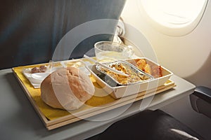 Portion of food for one passenger in cardboard box at airplane board.