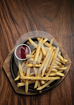 Portion of french fries potato snack on wood table background