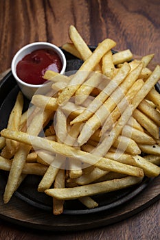 Portion of french fries potato snack on wood table background