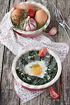 Portion of fresh baked egg with spinach .