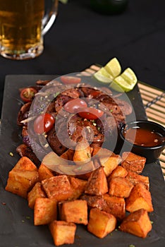 portion of fried Calabrian sausage with onion and roasted potatoes with spices and paprika