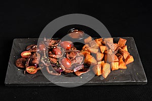 portion of fried Calabrian sausage with onion and roasted potatoes with spices and paprika