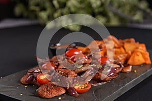 portion of fried Calabrian sausage with onion and roasted potatoes with spices and paprika