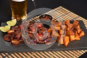 portion of fried Calabrian sausage with onion and roasted potatoes with spices and paprika