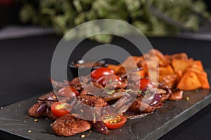portion of fried Calabrian sausage with onion and roasted potatoes with spices and paprika photo
