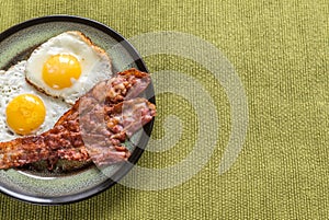 Portion of fried eggs with bacon