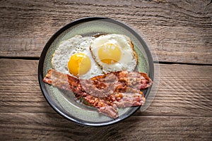 Portion of fried eggs with bacon