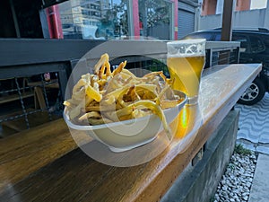 A Portion Of Fries With Beer In The Background.