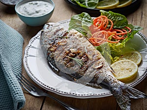 Grilled fish on wooden kitchen table