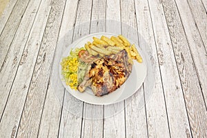 Portion of half roasted chicken with potatoes and salad with lettuce and sweet corn