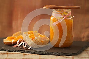 Portion of hollow bread with homemade orange marmalade and a rustic background