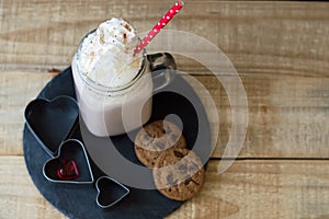 Portion of hot chocolate with whipped cream topping and red stra