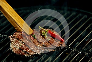 Portion of hot spicy beef steak grilling on a BBQ photo