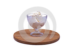 Portion of ice cream in a crystal glass on a wooden board