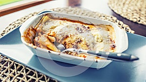 Portion of Lasagme bolognese in dish on table in restaurant