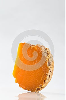 Portion of Mimolette Cheese on white background